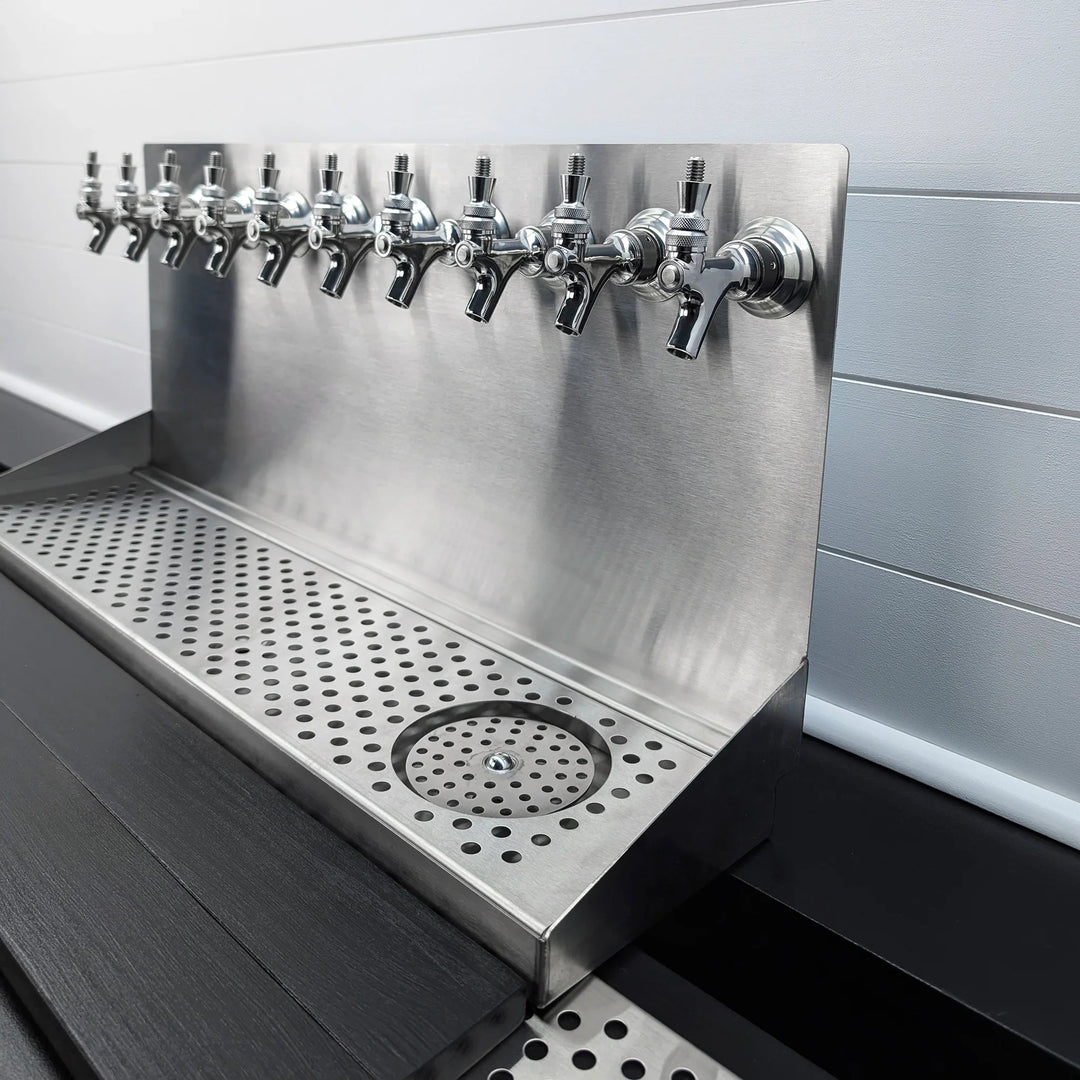 Stainless steel wall mount beer drip tray with multiple faucet holes and a circular glass rinser at the bottom