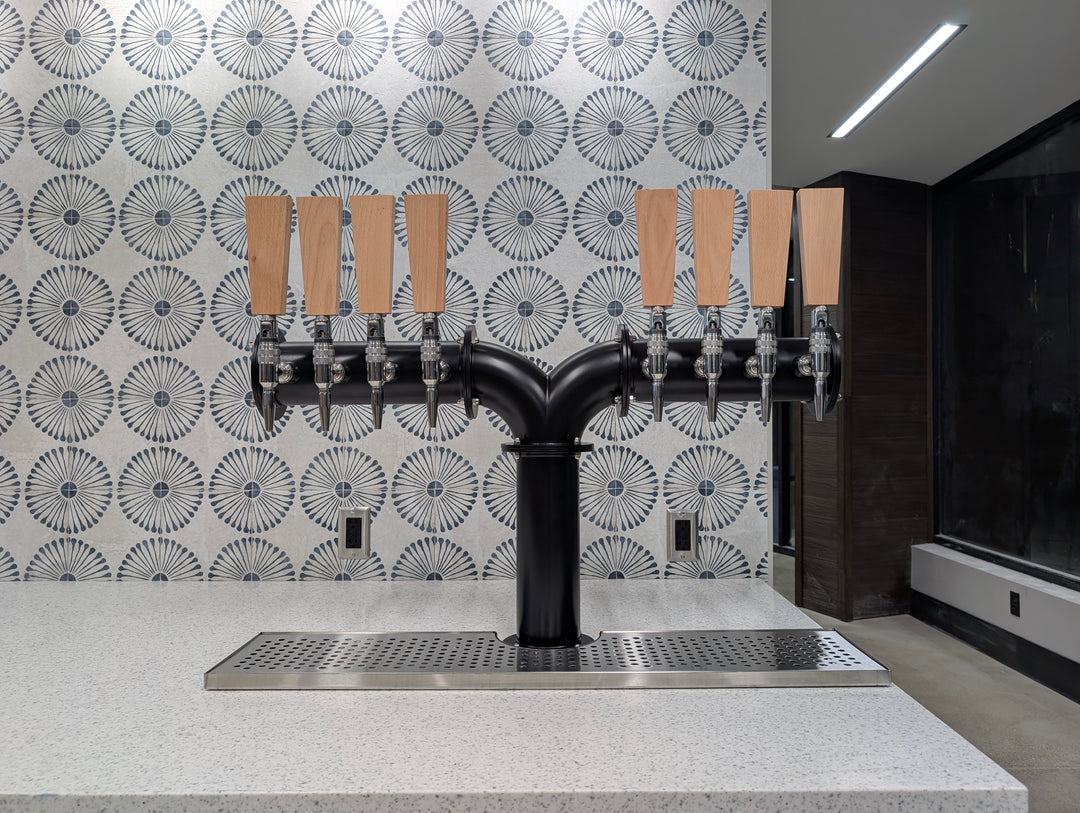 Black Y-pipe six tap draft tower with wood tap handles on a convenience store countertop
