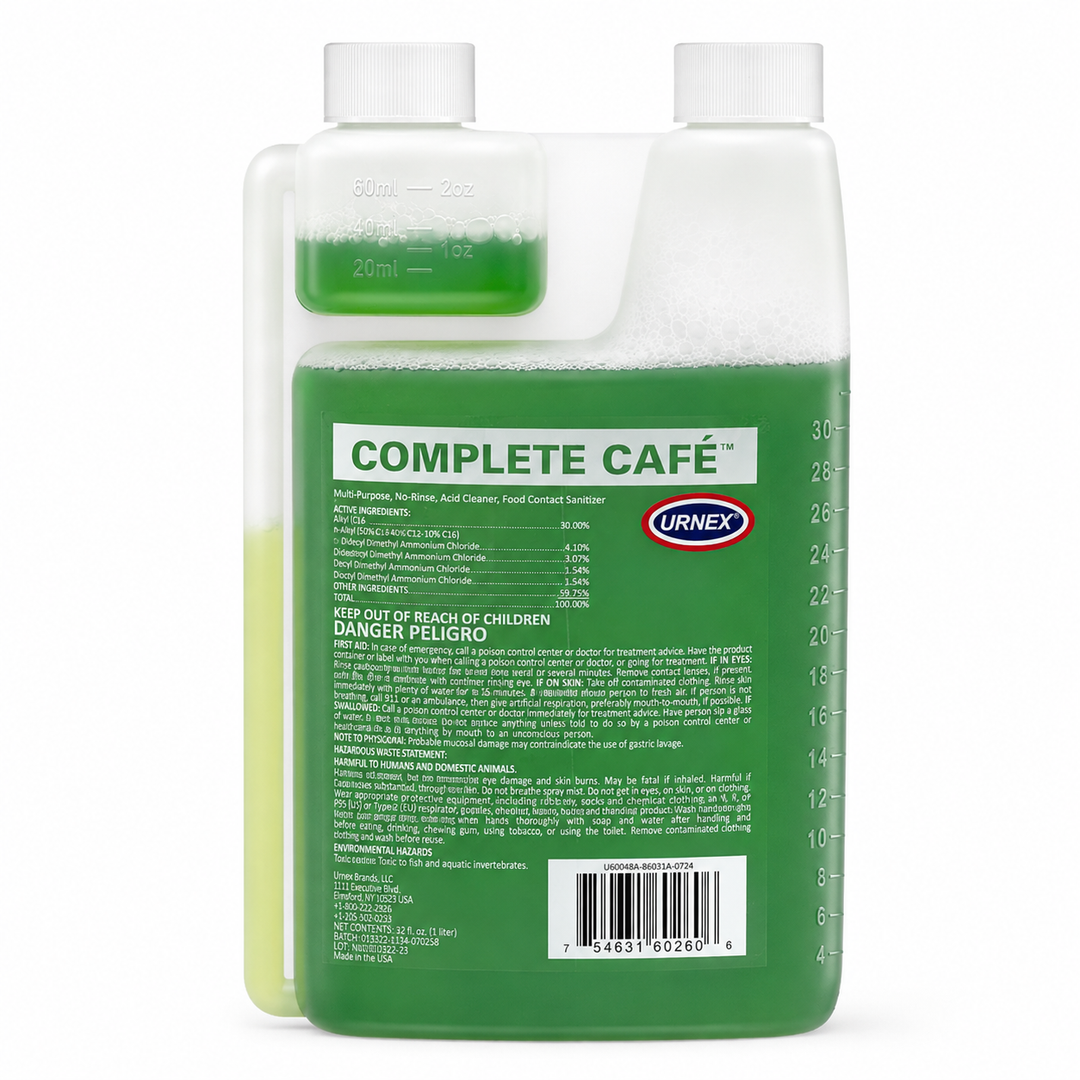 A bottle of Urnex Complete Café liquid cleaning product, showing the front measurement window and the back label with product information, barcode, and warning text.